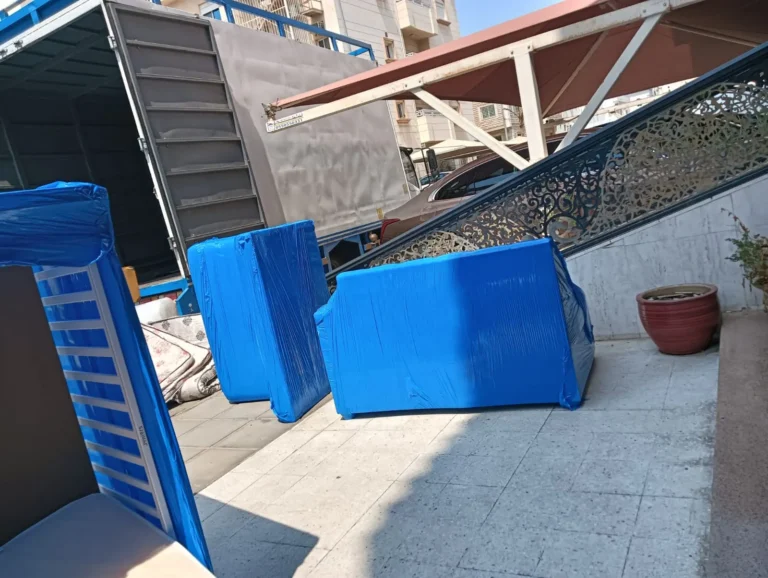 قطع كنب مغطاة ببطانيات حماية زرقاء بجانب سيارة النقل